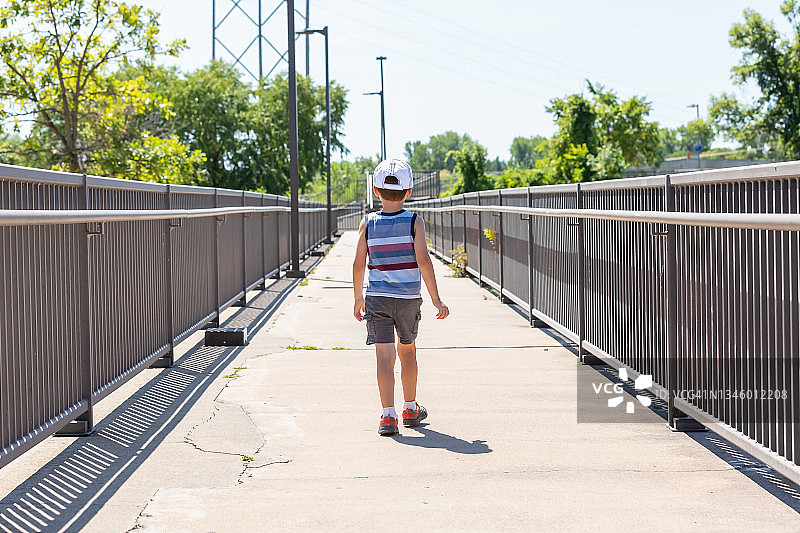 男孩走过桥梁走道的背影图片素材