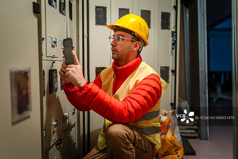 电工在工业配电盘中维修断路器图片素材