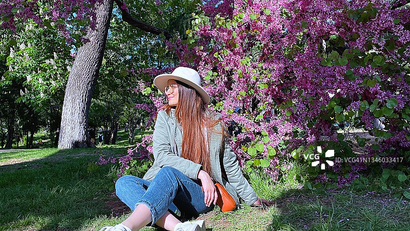 戴帽女孩坐在公园里图片素材