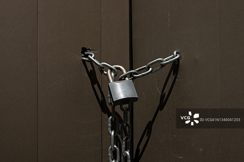 棕色金属门上的挂锁和链条图片素材