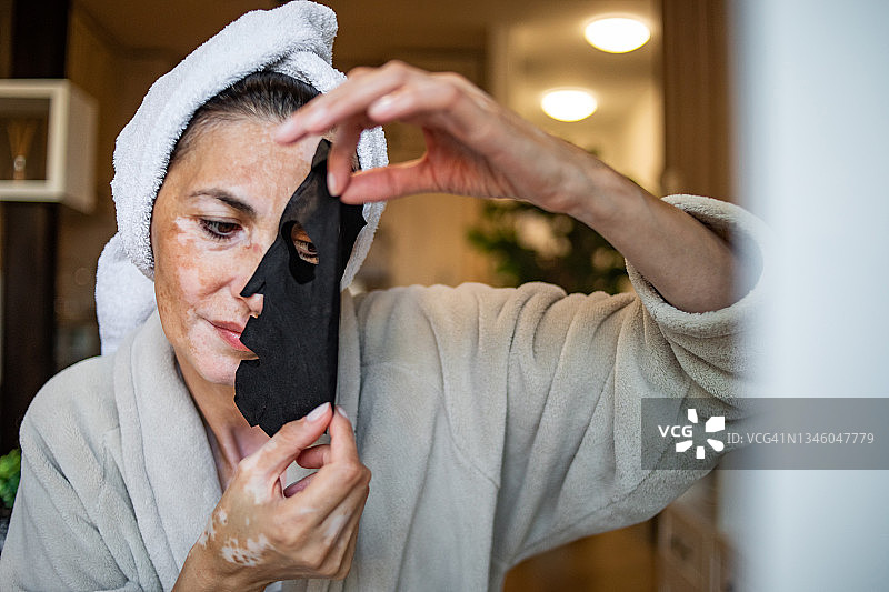 裹着浴巾的美丽女士正在护理皮肤图片素材