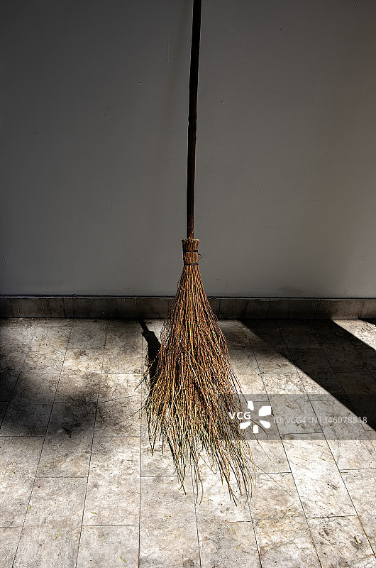 靠在建筑物外墙上的树枝扫帚图片素材