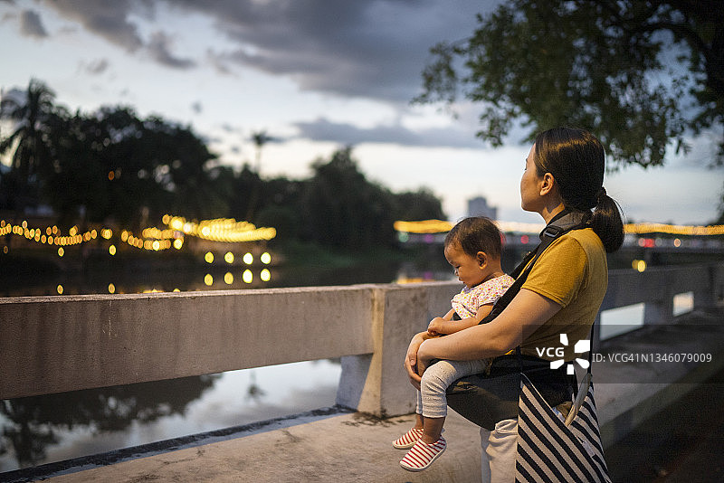 未戴口罩的亚洲母亲抱女儿图片素材
