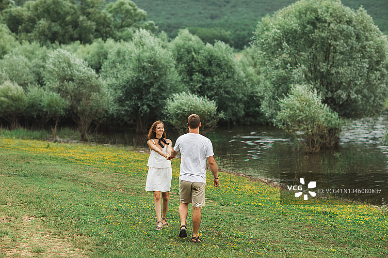 在湖边大自然中一起散步的浪漫幸福情侣图片素材