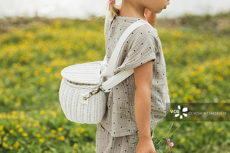 小女孩身上的白色藤条编织背包特写图片素材