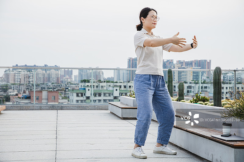 在平台上练习太极的亚洲女商人图片素材