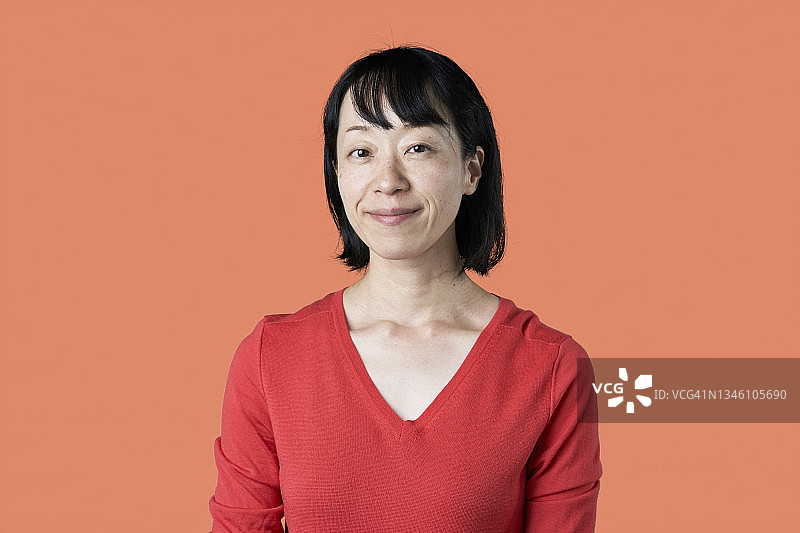 橙色背景上的日本中年妇女肖像图片素材