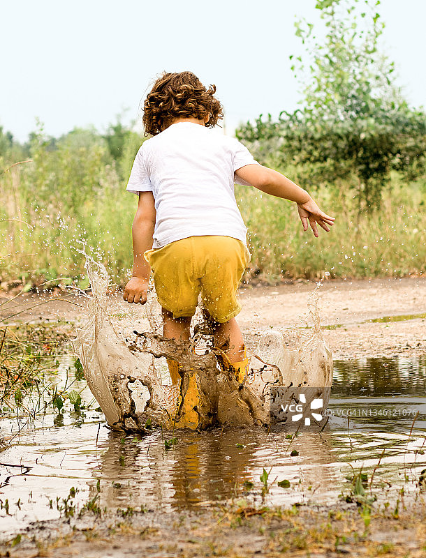 在泥坑里玩耍的小孩图片素材