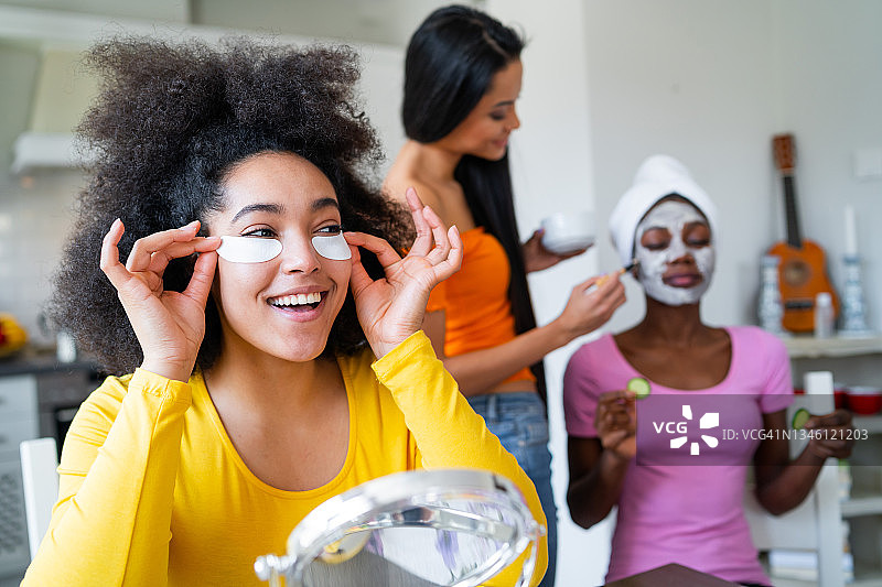 一群微笑美丽的年轻女性在家互相进行美容图片素材