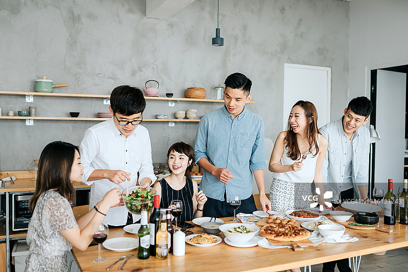 一群快乐的年轻朋友一起玩耍，在聚会上分享食物图片素材