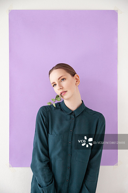 年轻女模特用树枝触摸脸庞图片素材