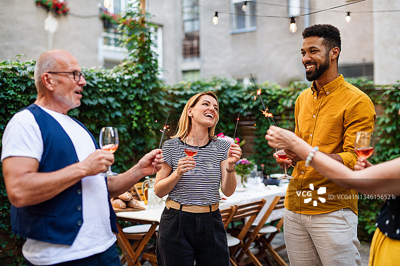 快乐的多种族家庭在花园里庆祝生日图片素材