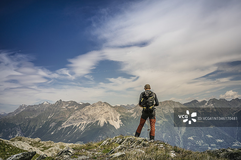 徒步者站在山顶俯瞰山谷图片素材