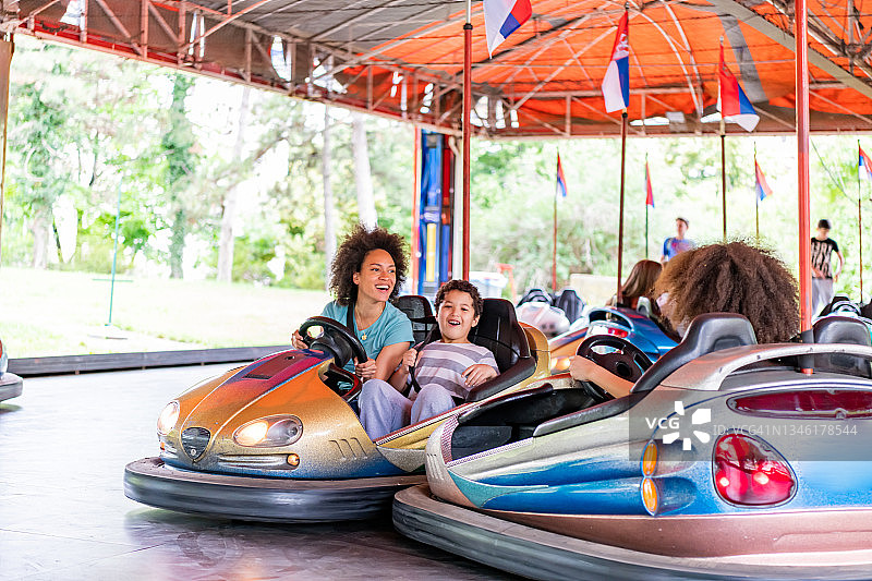 快乐的母亲和可爱的非裔美国孩子在游乐园玩耍图片素材