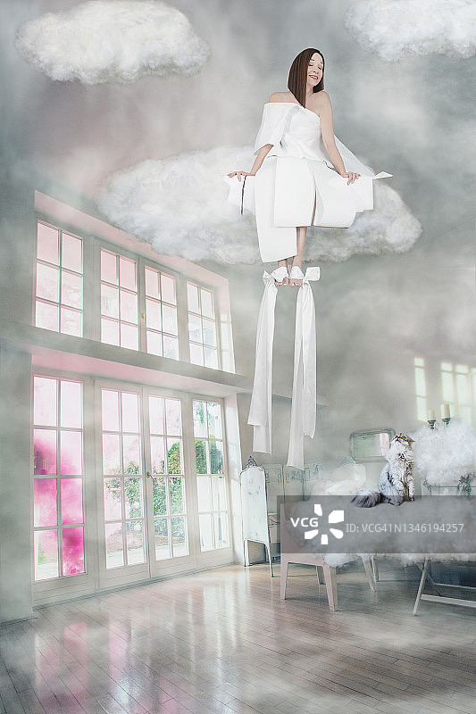 女子坐在云端微笑图片素材