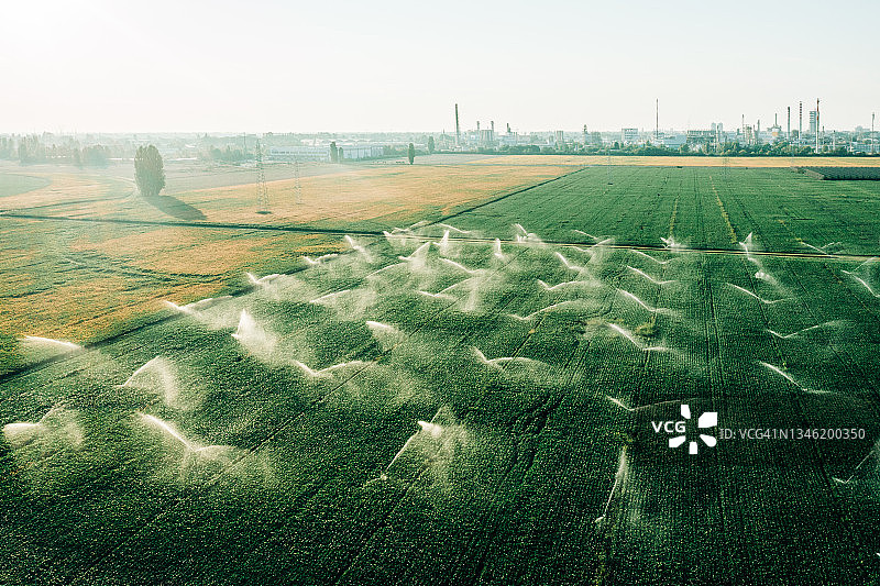 电站前农田喷水灌溉的日出鸟瞰图图片素材