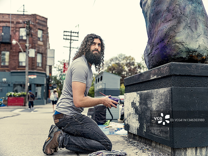 年轻艺术家创作街头雕塑图片素材