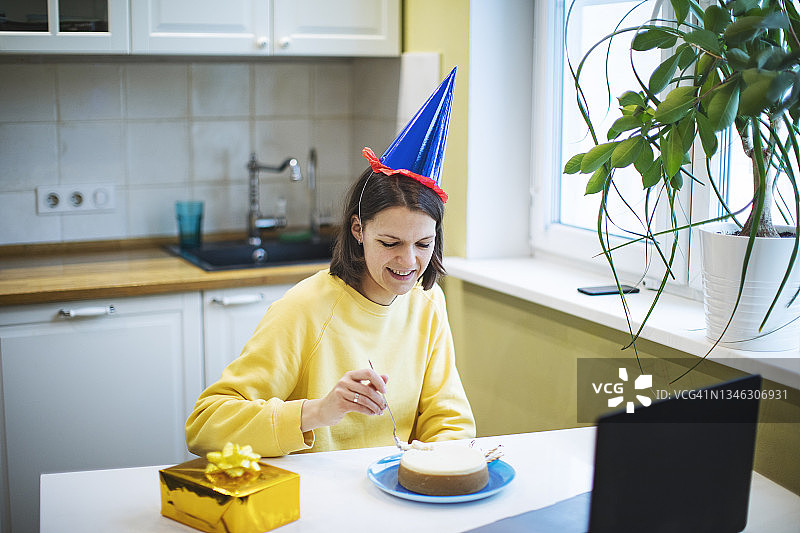 在家与朋友通过视频通话庆祝生日的年轻女子图片素材