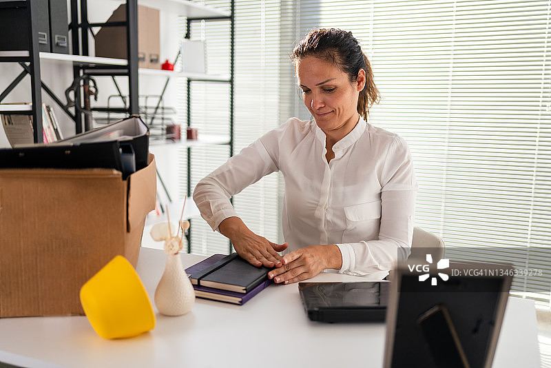 微笑的千禧一代新女员工在办公室拆箱图片素材