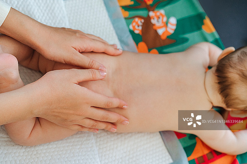 母亲的手给可爱的宝宝按摩图片素材