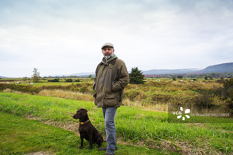 一位中年男人在秋日与他的狗在乡下图片素材