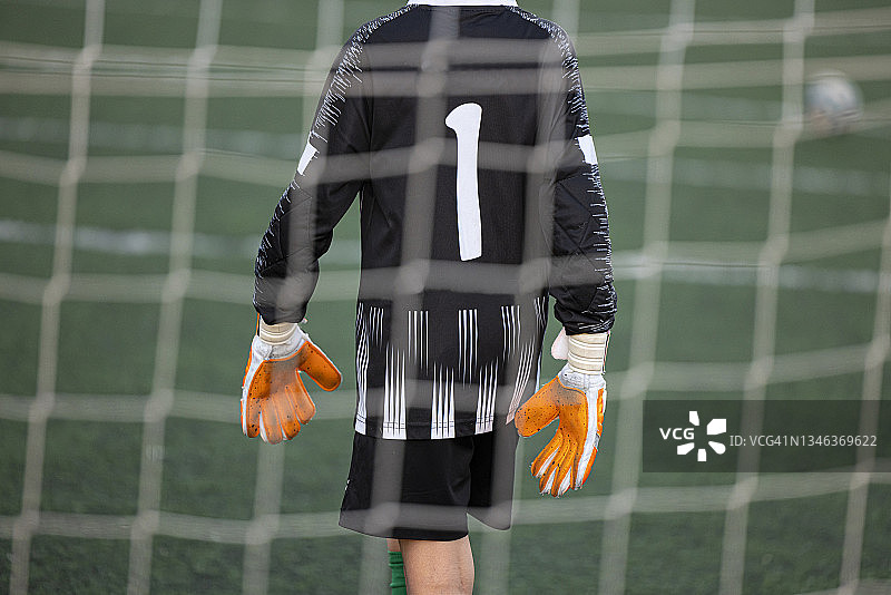 准备好站在球网后的年轻守门员图片素材