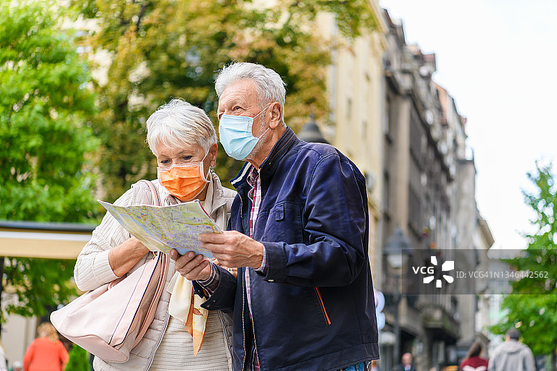 疫情期间老年游客使用城市地图观光图片素材