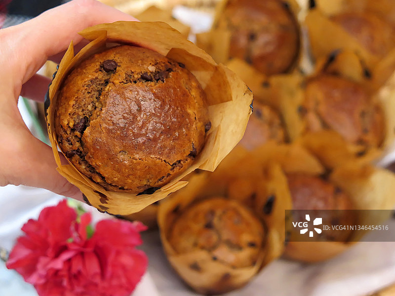 女人拿着一块巧克力麦芬蛋糕图片素材
