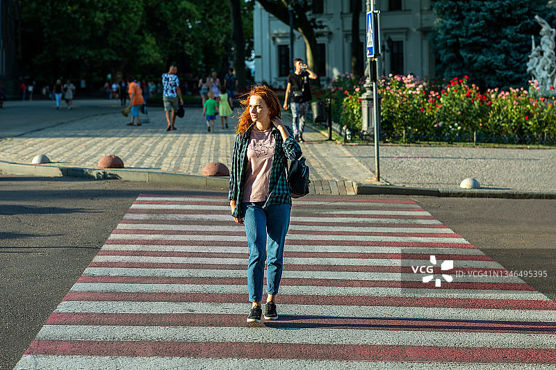年轻女人在街上的人行横道行走图片素材
