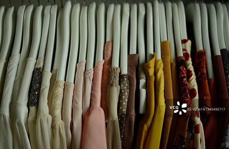 挂在衣架上颜色各异的女衬衫（按颜色排列）图片素材