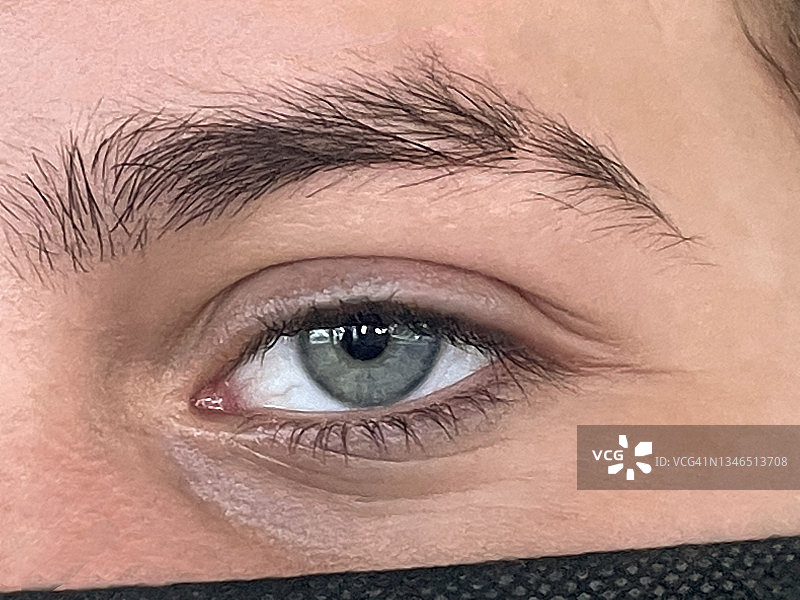 少年蓝色眼睛特写，眉毛处有切口，直视镜头，面部露出黑色口罩图片素材