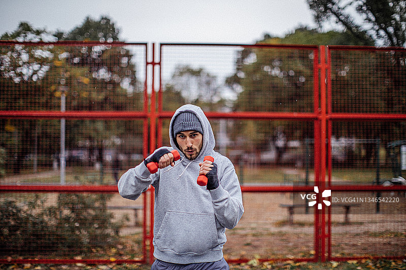20多岁的年轻男子在雨天进行举重训练图片素材