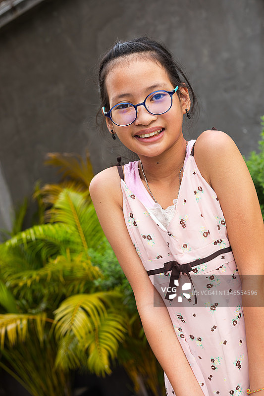 戴眼镜的害羞微笑的泰国年轻女孩图片素材