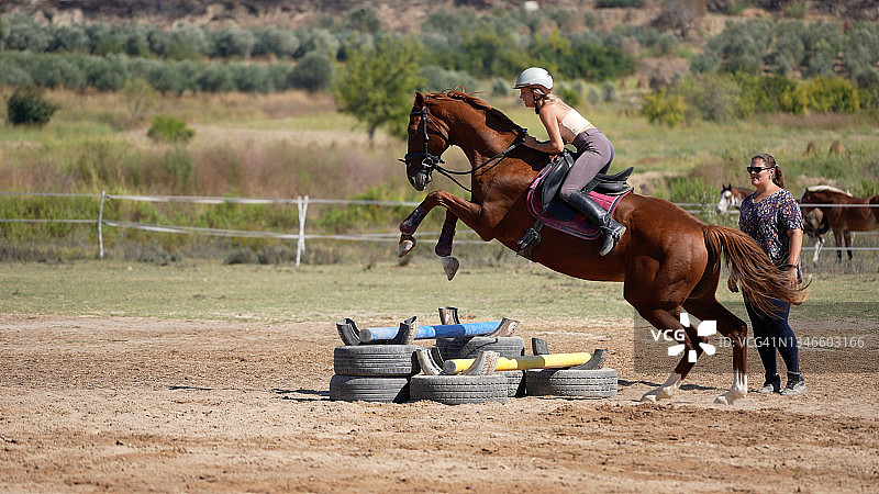 年轻女人在教练的指导下学习跨越障碍图片素材