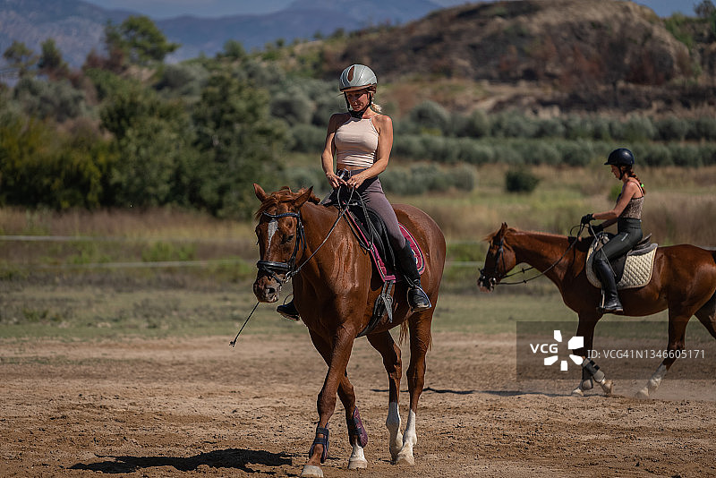 两位年轻女士在农场上骑马课图片素材