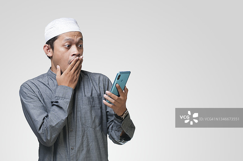 穆斯林男子震惊地看着智能手机图片素材