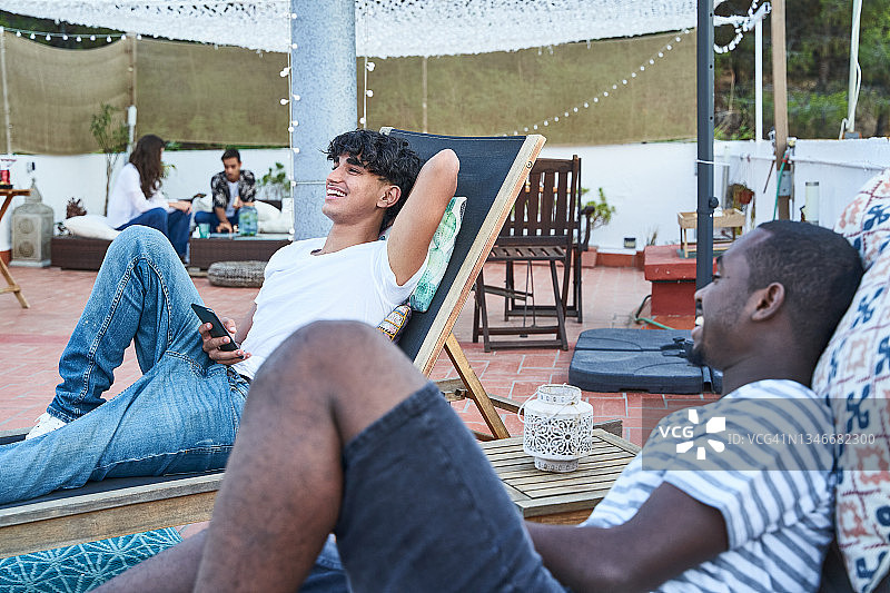 年轻的朋友们在夏天酒店的露台上享受假期图片素材