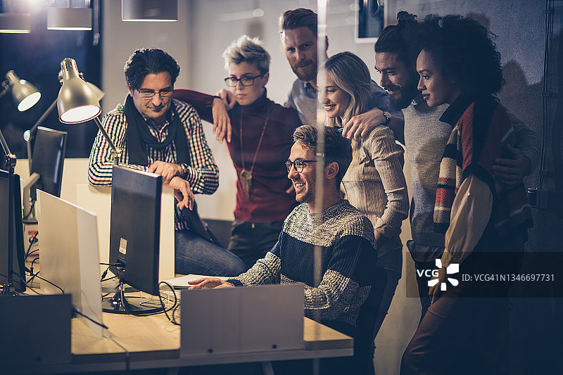 年轻程序员和同事在办公室使用台式电脑图片素材