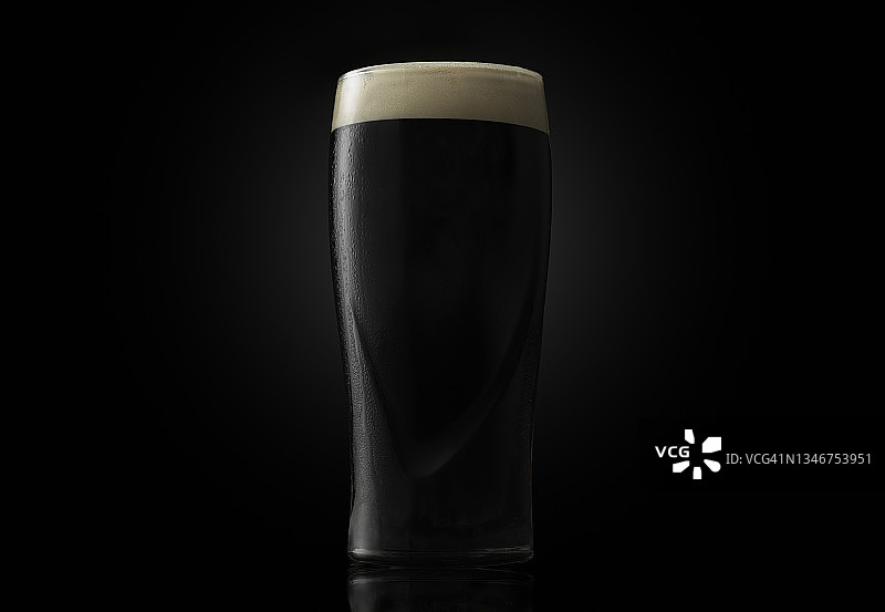 品脱杯装黑啤酒，深色背景图片素材