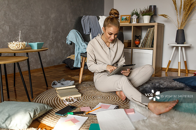 女学生在学习时查看数位平板电脑上的课程表的全身照图片素材