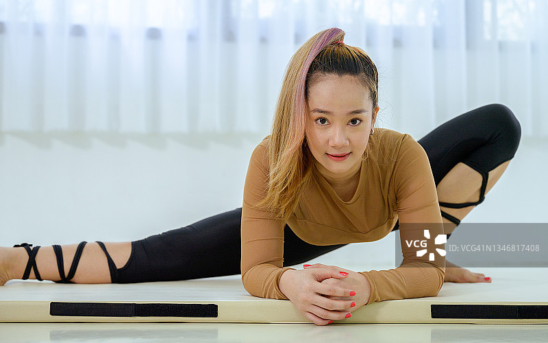 在空中瑜伽馆热身的迷人亚洲年轻女性图片素材