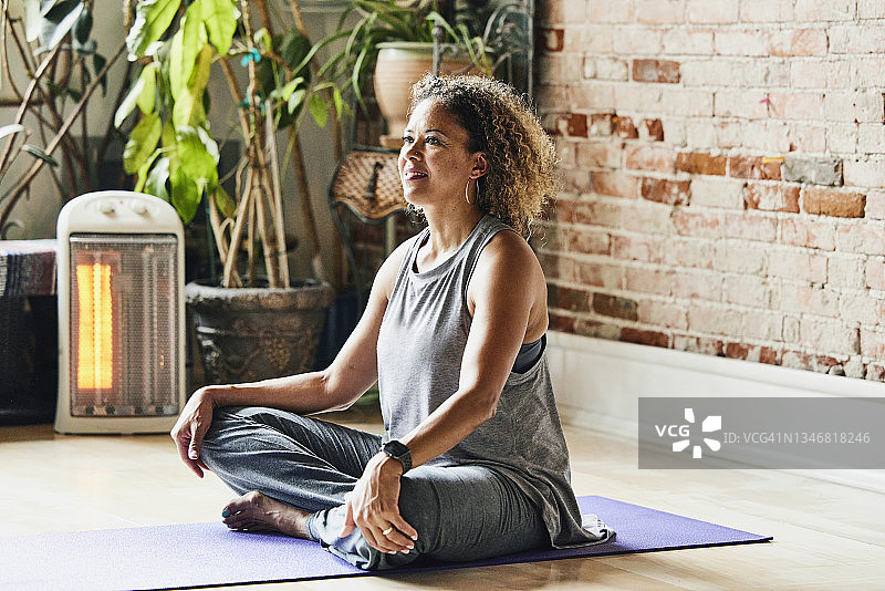 课前坐在工作室里微笑的成熟瑜伽教练图片素材