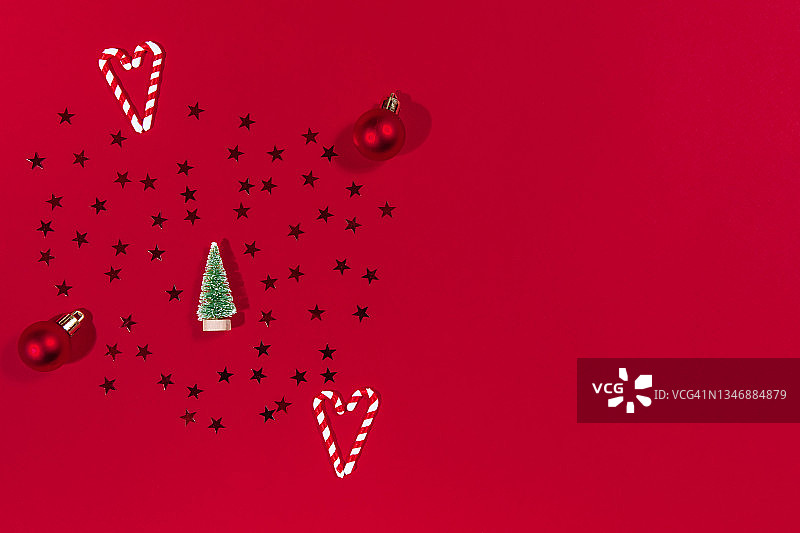 红色背景上的圣诞树、蜜饯、拐杖和彩球图片素材