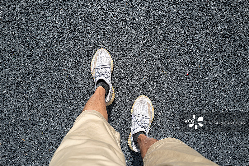 俯瞰在沥青路上行走的人的脚图片素材