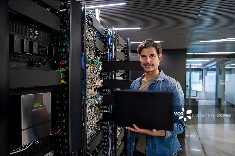 在服务器机房工作的快乐IT技术员图片素材