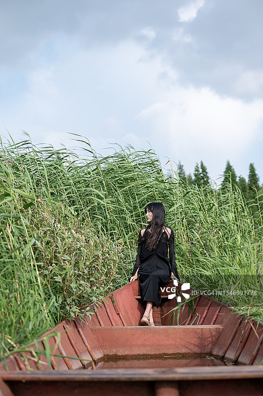 在红色船上的黑衣女孩图片素材