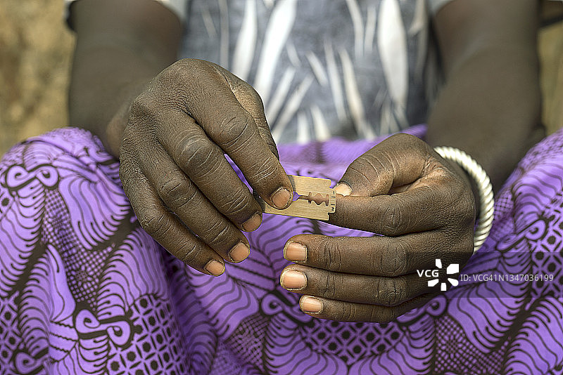 在布基纳法索东部，一名妇女拿着剃须刀片图片素材