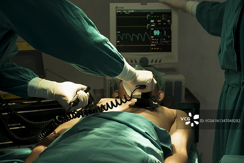 外科医生使用自动体外除颤器或AED帮助病人图片素材