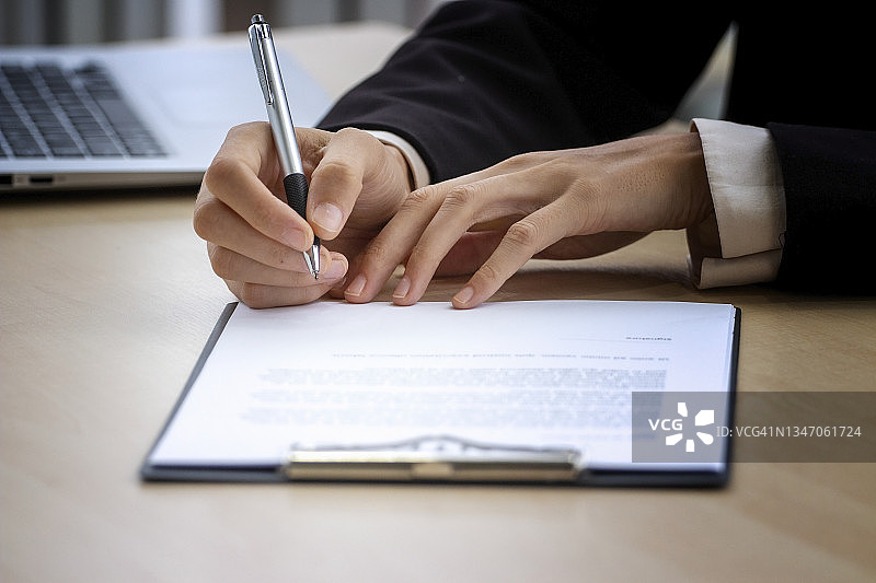 商务概念：办公室里签署文件的商人特写图片素材