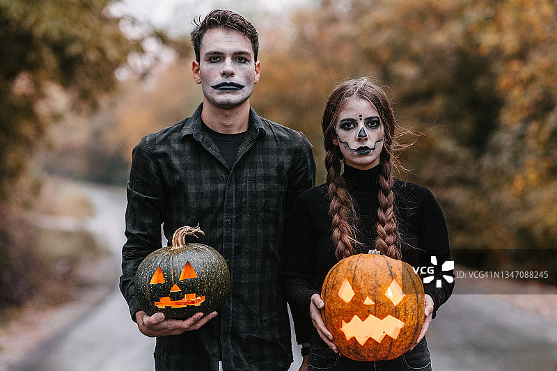 情侣在路上手持弯曲的南瓜图片素材